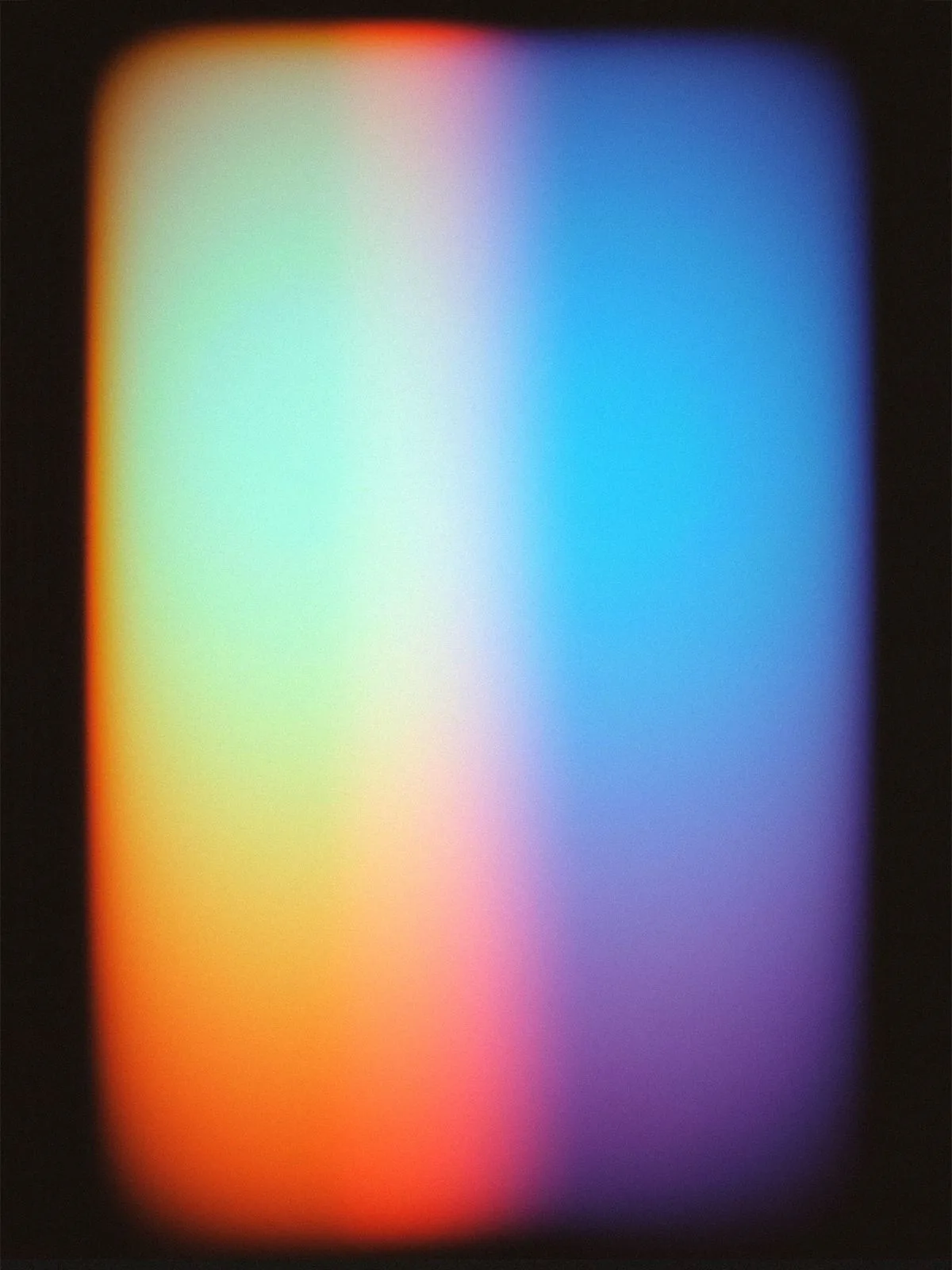 A soft, blurred rectangle of light on black: orange and mint green on the left, blue and purple on the right.